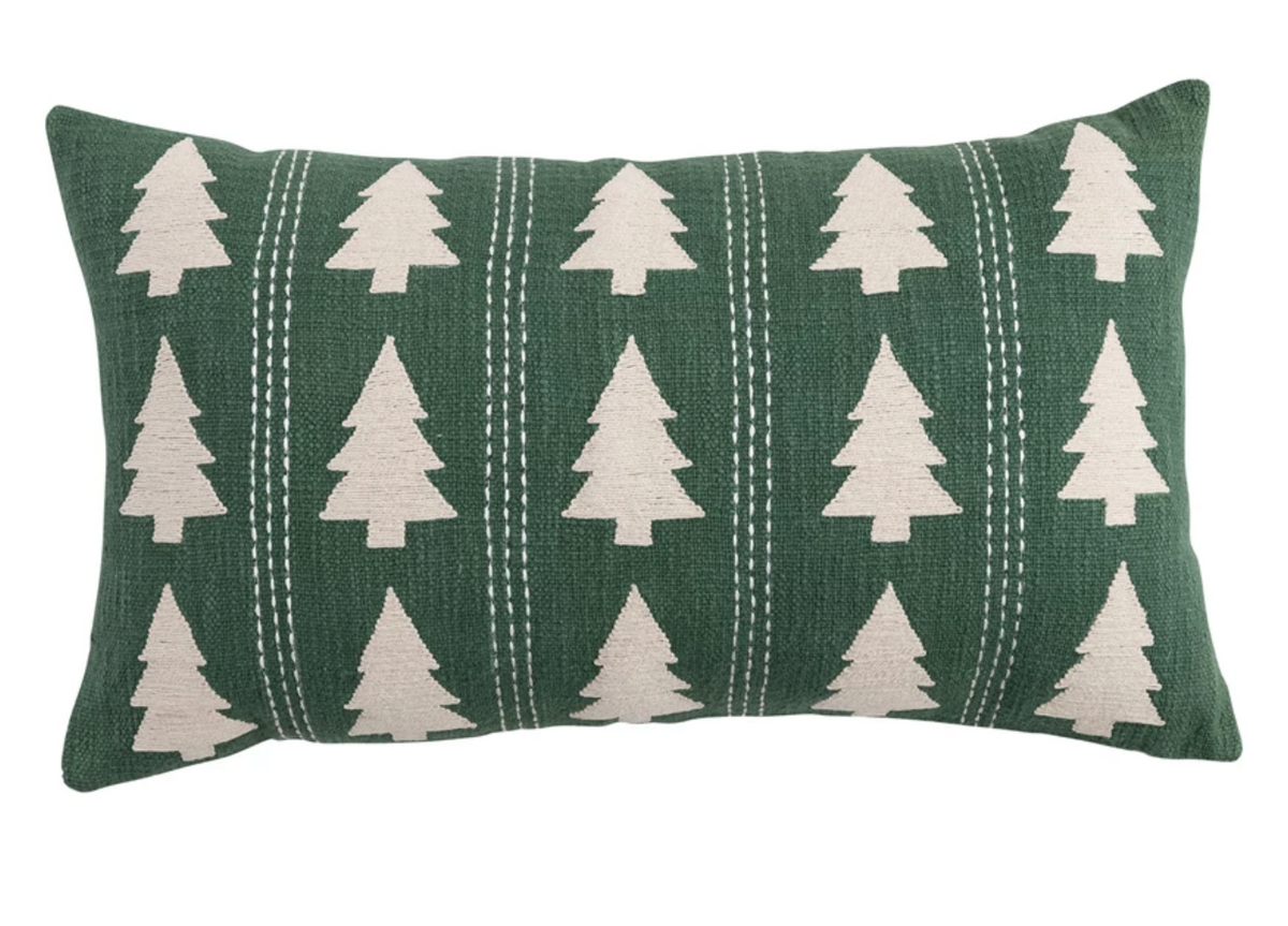 Natural cotton slub lumbar pillow with embroidered evergreen trees and decorative stitching in soft green tones.