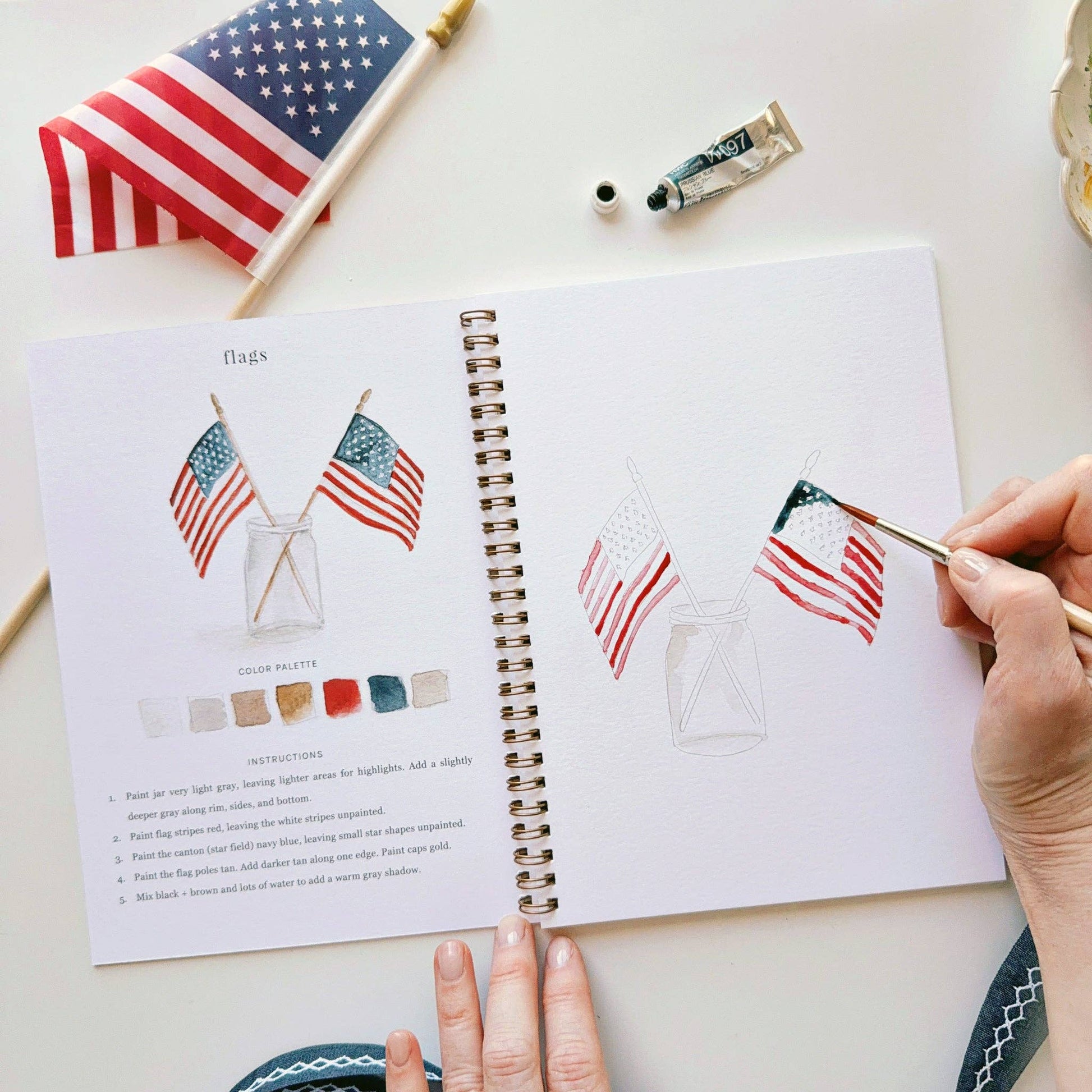Step-by-step watercolor workbook with pre-outlined Americana illustrations ready to paint.