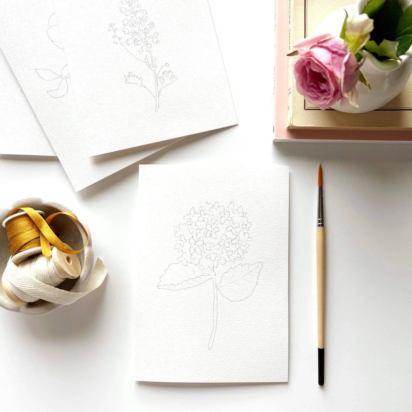 Paintable watercolor notecards featuring hydrangea, garden rose, delphinium, and daisy illustrations.