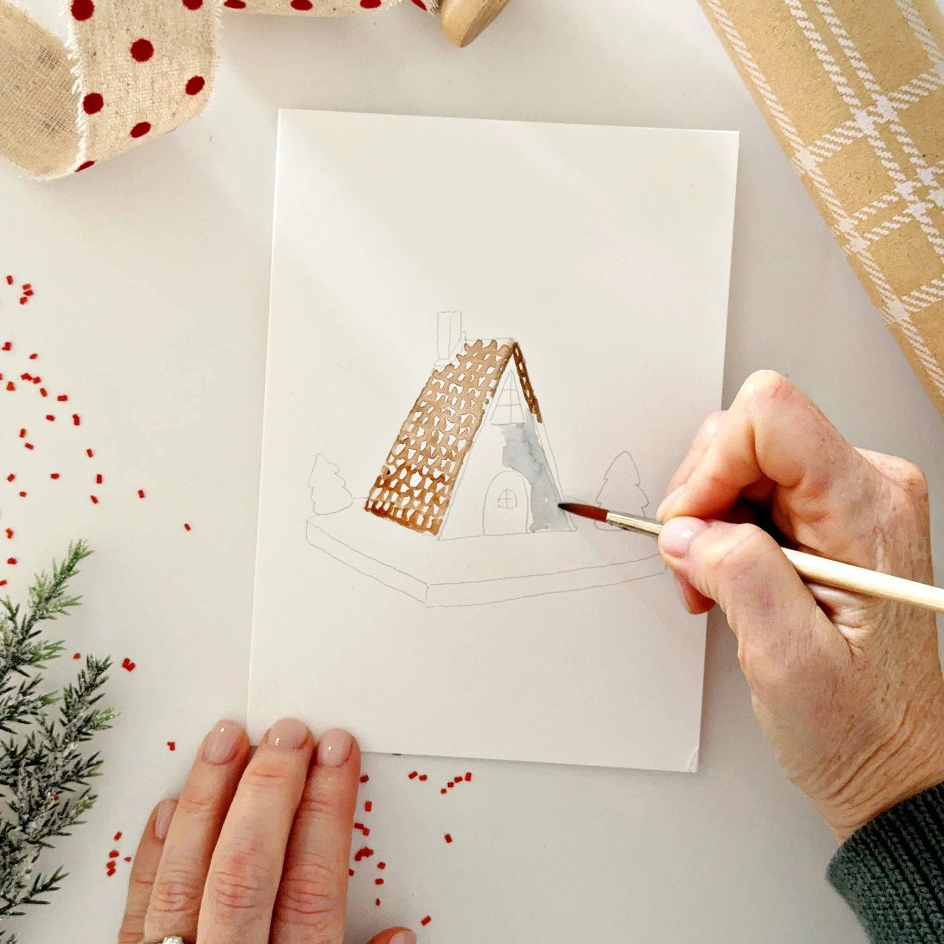 Close-up of watercolor-ready Christmas notecards featuring festive gingerbread and holiday illustrations printed on premium watercolor paper.