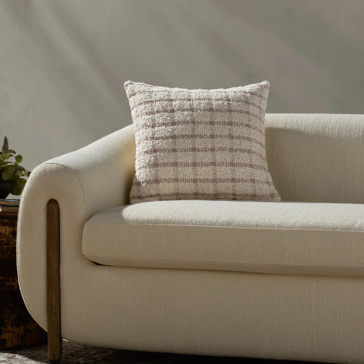 Erin Ivory and Natural throw pillow layered on a linen sofa with warm wood furniture, textured wool throws, and handcrafted ceramics in an organic modern living room.