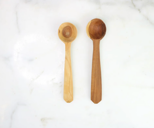 Two wooden spoons, one light wood and one dark wood, on a white background