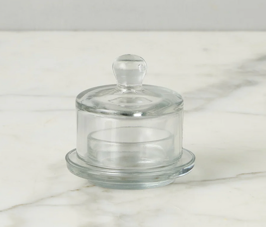 Clear glass jam jar stand with lid on a marble surface