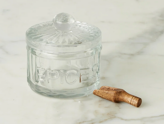 Clear glass jar with a wooden lid on a marble surface