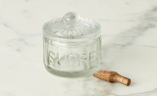 Clear glass jar labeled 'SUCRE' on a marble surface