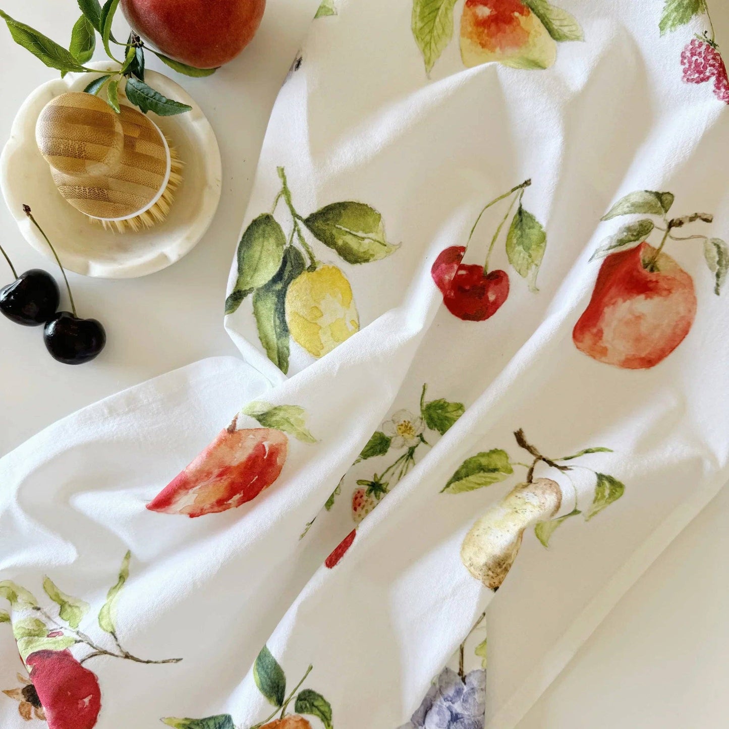 Fruit tea towel styled in a bright farmhouse-inspired kitchen.