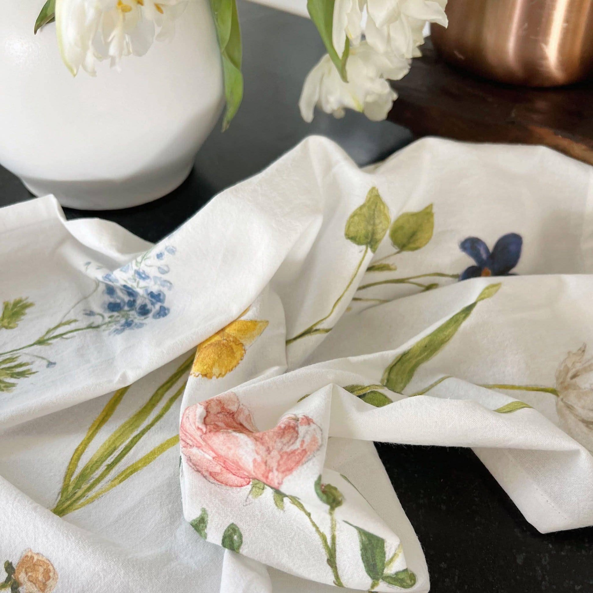 Floral tea towel styled in a cottage-inspired kitchen with natural textures.