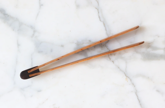 Wooden tongs on a marble surface