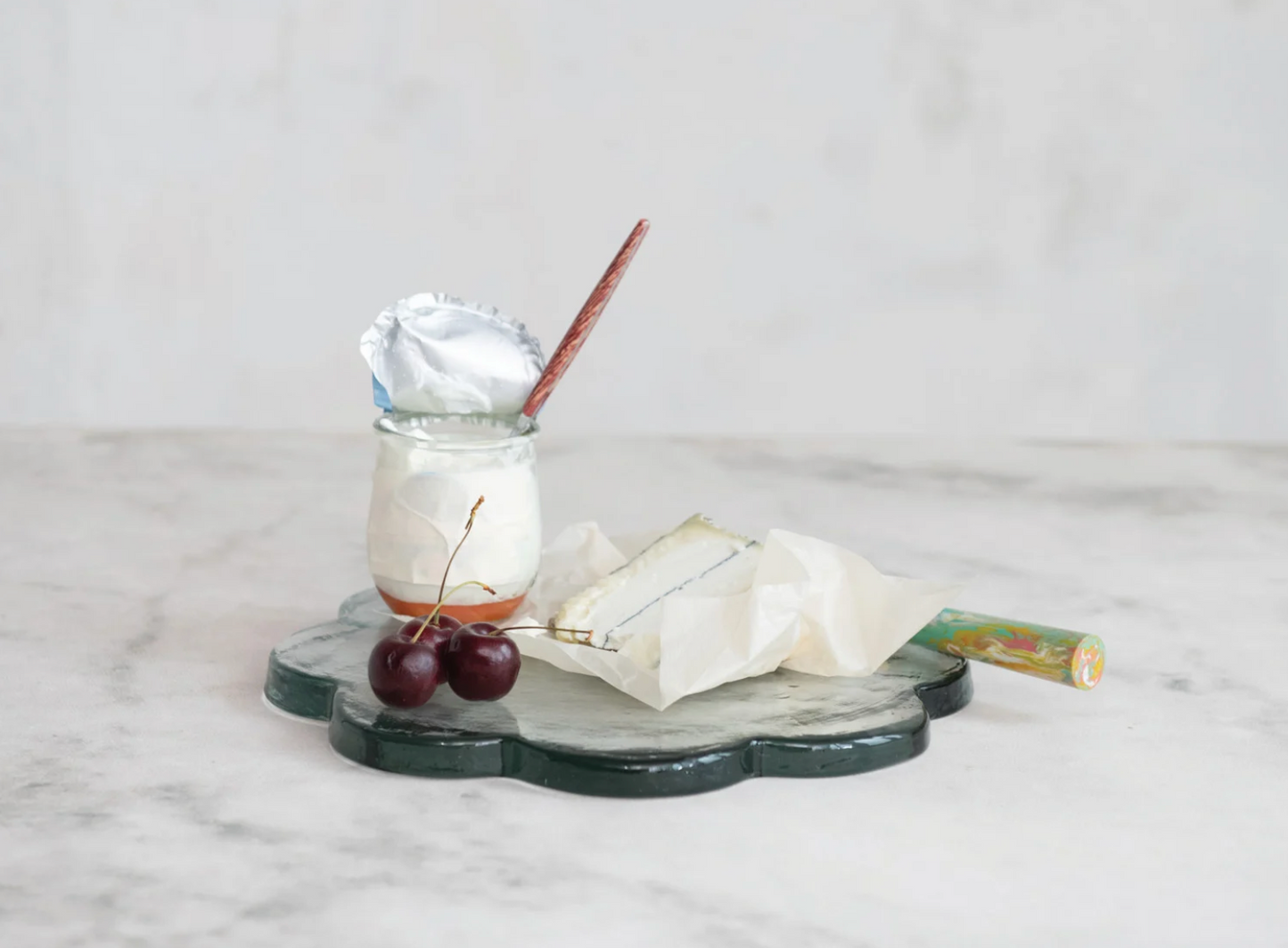 Scalloped glass serving board styled with artisan cheeses and charcuterie for elegant entertaining.