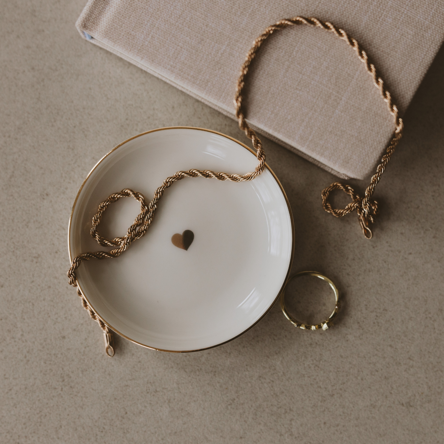 Cream ceramic jewelry dish featuring a delicate gold foil heart at the center.