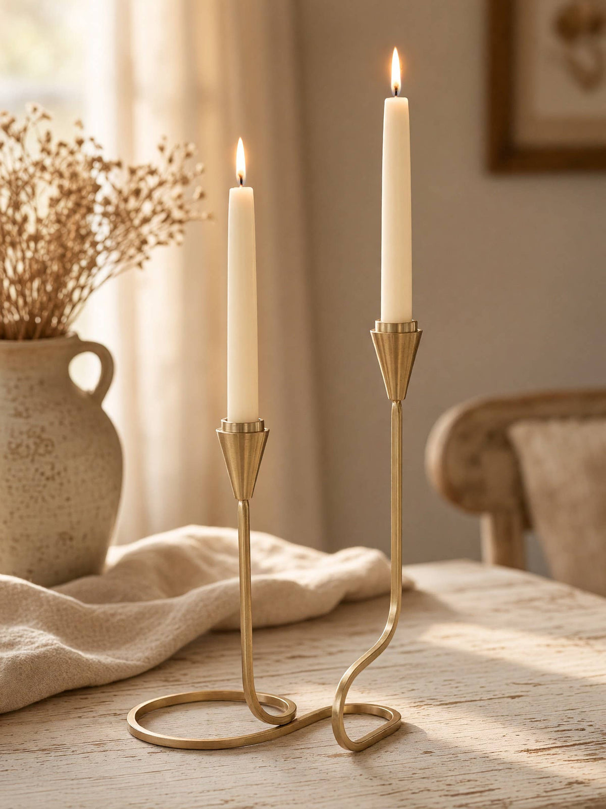Handcrafted gold iron taper candle holder with a distinctive sculptural loop design.