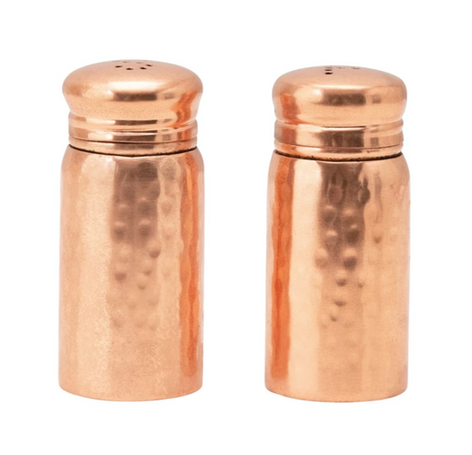Set of two hammered copper salt and pepper shakers with warm metallic finish and artisan texture.