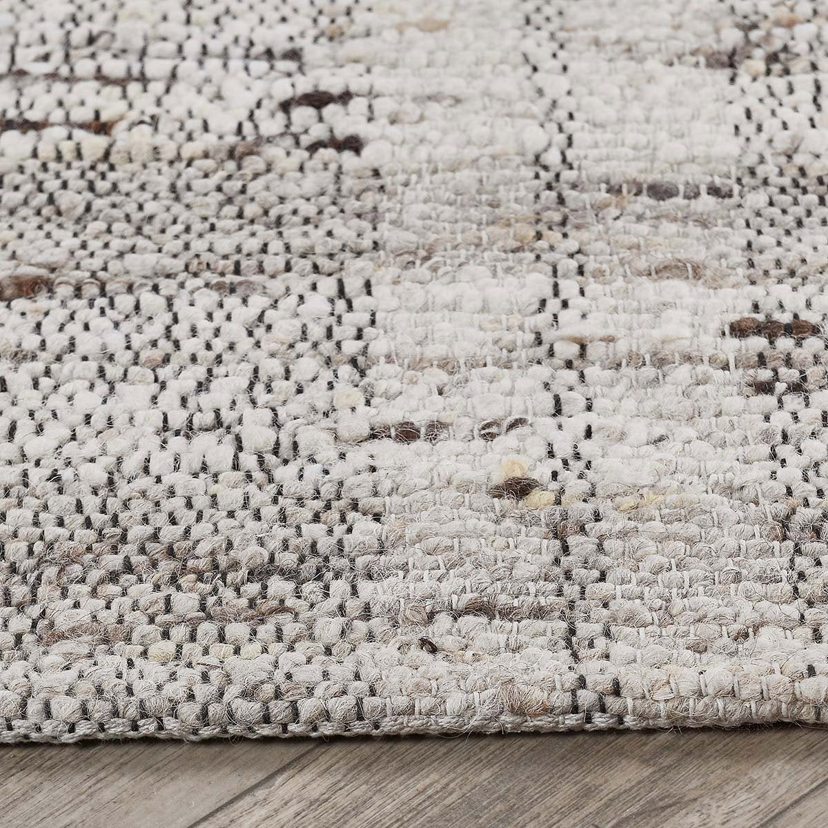 Close-up of the Perth rug showcasing the lofty hand-carded wool, subtle plaid detailing, and artisan handwoven craftsmanship.
