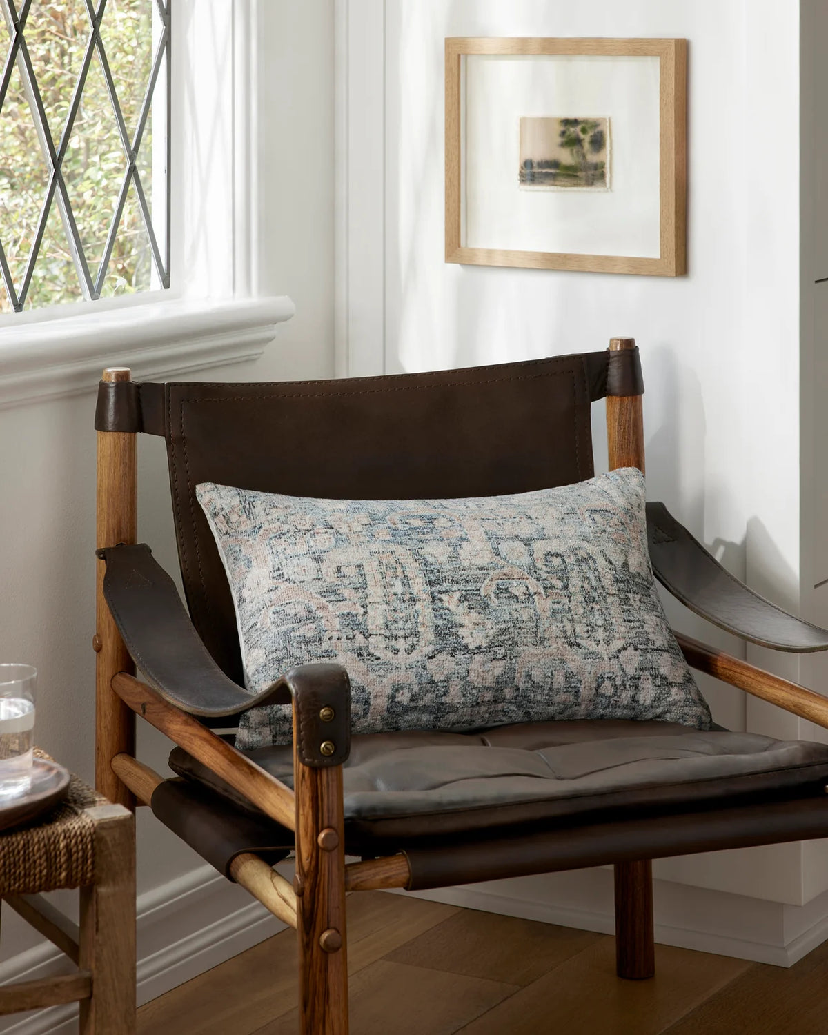 Humboldt Ocean and Clay lumbar pillow styled on a leather accent chair, natural wood and white walls.