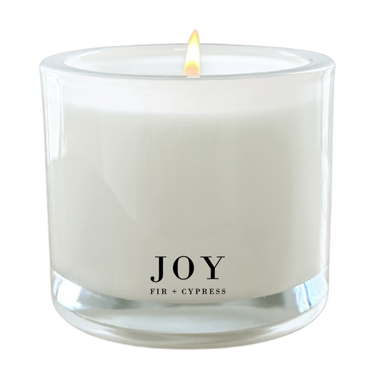 Joy Fir + Cypress 9 oz coconut wax candle in a frosted glass jar featuring the fresh scent of evergreen, fir, cedar, and cypress.
