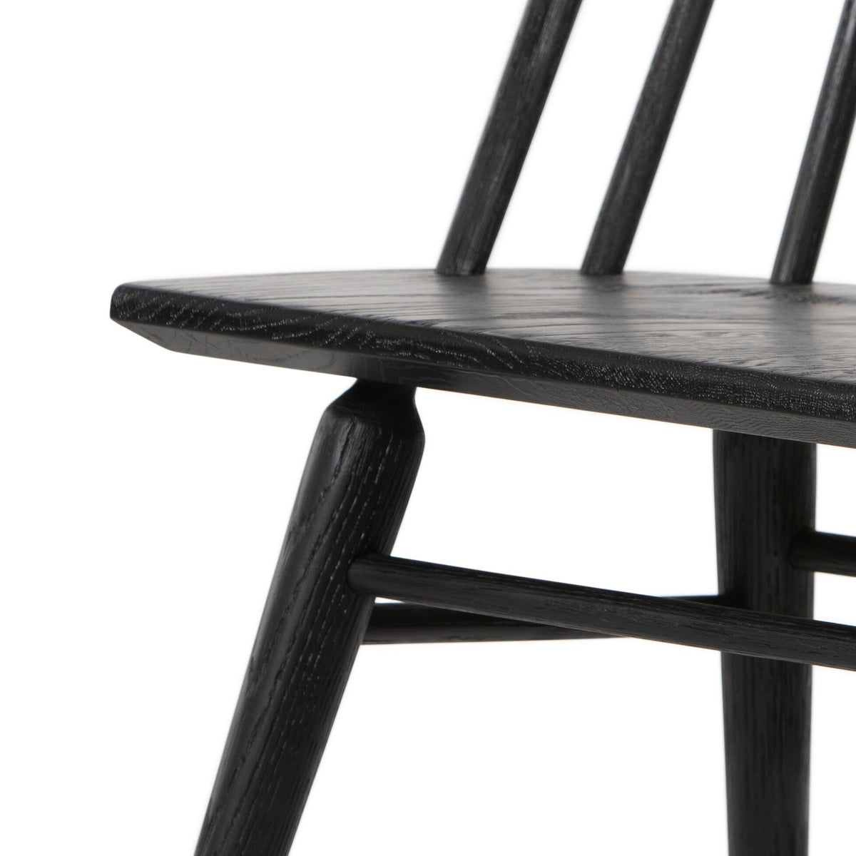 Close-up of the wire-brushed black oak grain on the seat and frame of the Lewis Windsor Dining Chair.