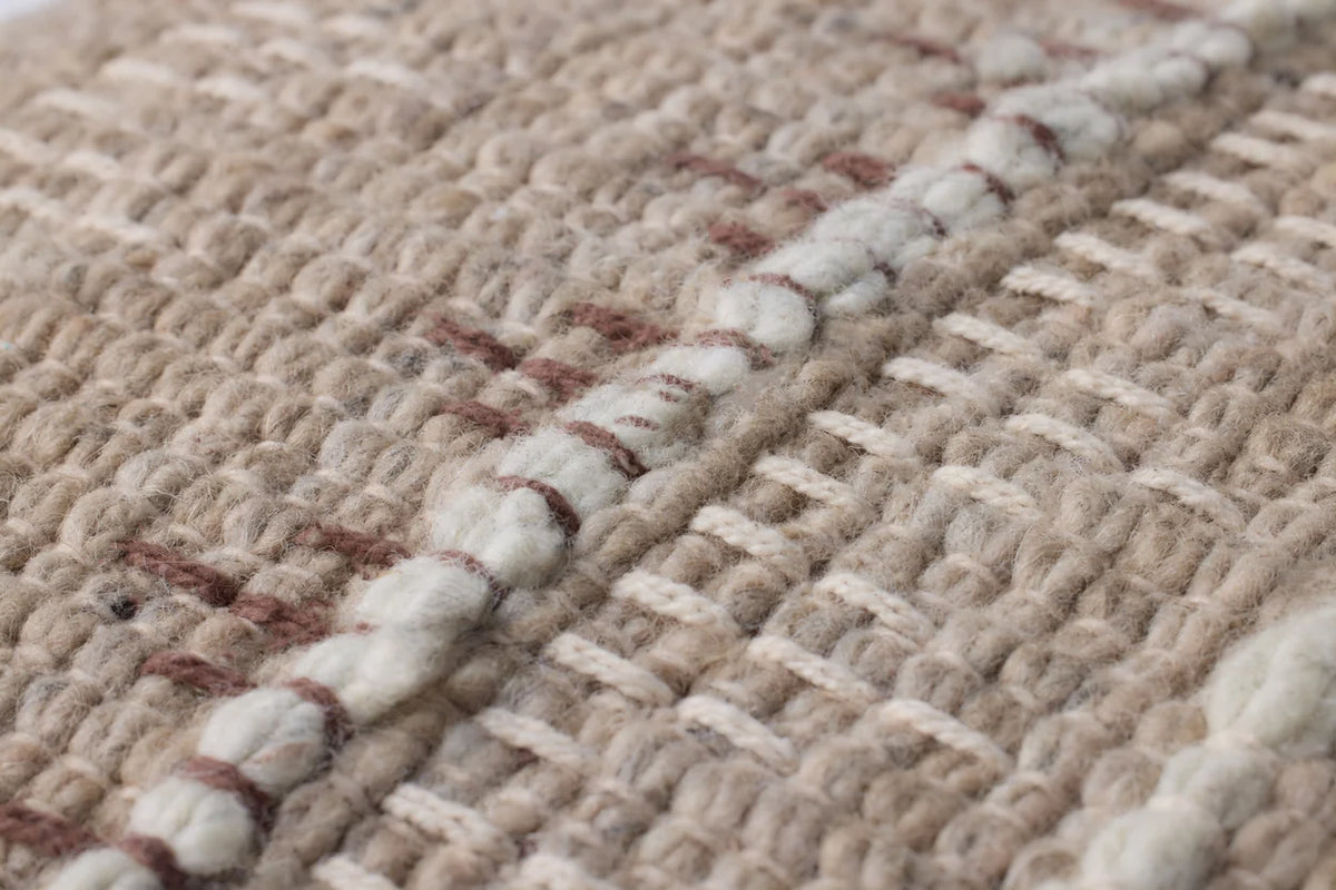 Close-up of the handwoven wool and cotton pillow showcasing the artisan texture, hidden zipper with antique bronze Loloi logo pull, and neutral woven fibers.