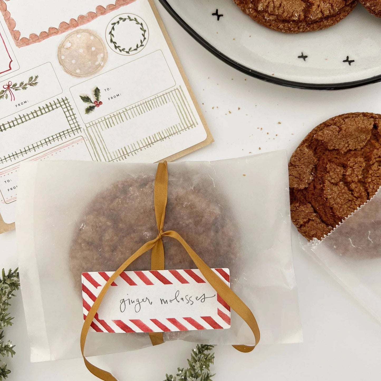 Packaged ginger molasses cookies with a decorative ribbon on a white surface.