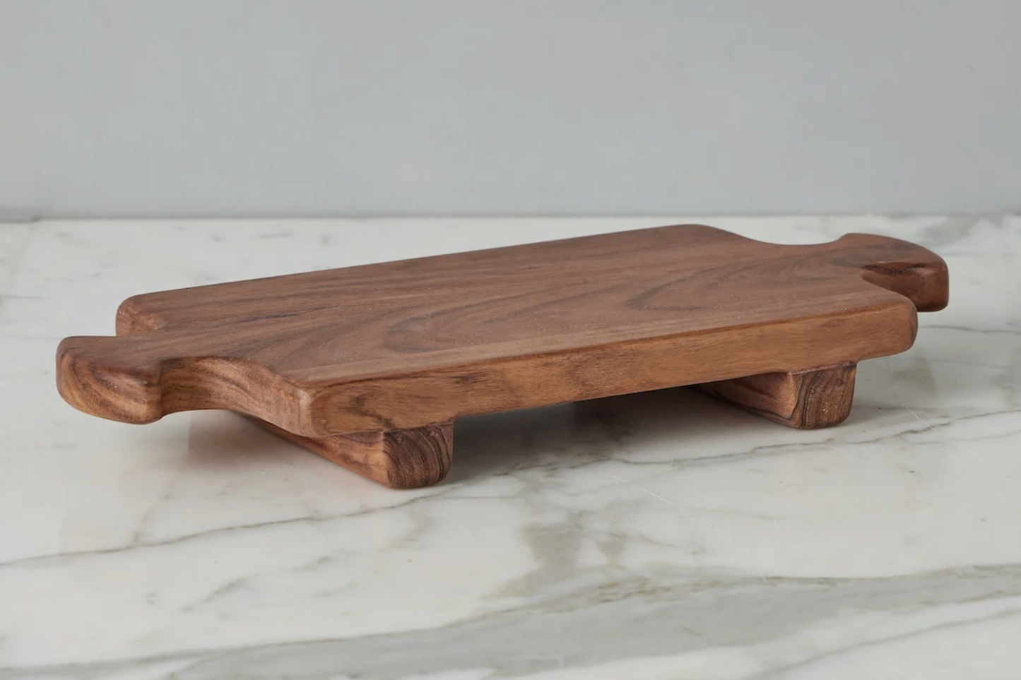 Wooden cutting board on a marble surface with a gray background