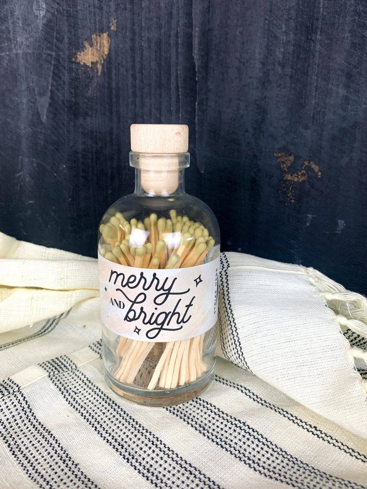 Gold-tipped wooden matches inside a glass apothecary jar with cork top.