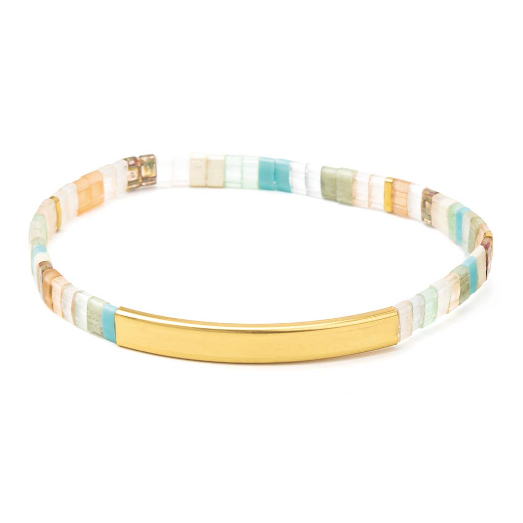 Good Karma Miyuki Bracelet featuring mint, peach, and gold Japanese Miyuki glass beads with a 14K gold-dipped engraved bar and Sparkle & Shine leather keepsake tag.