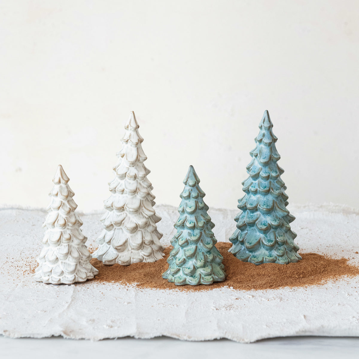 Cream reactive glaze stoneware Christmas trees in small and large sizes with naturally varied glazed finishes.