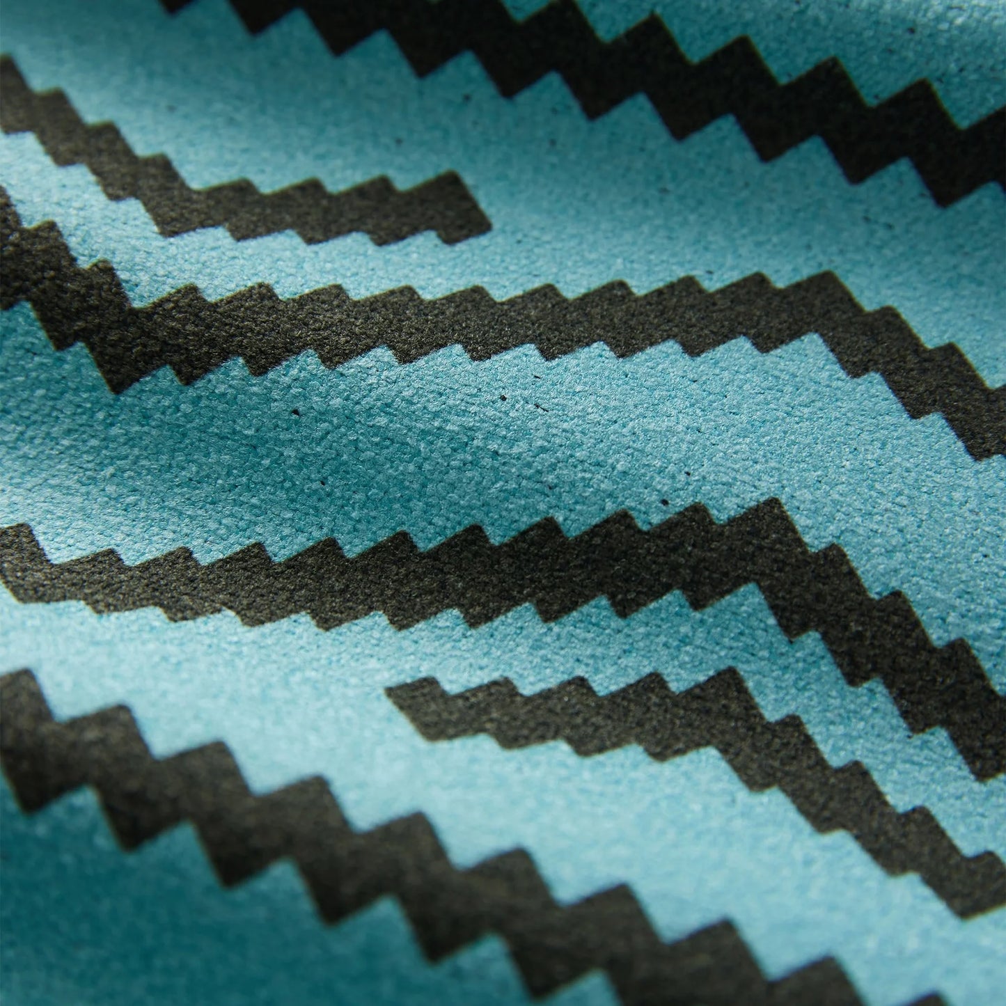 Close-up of the Baja Aqua Nomadix towel showing the textured performance fabric, bold woven-inspired pattern, and built-in hanging loop.