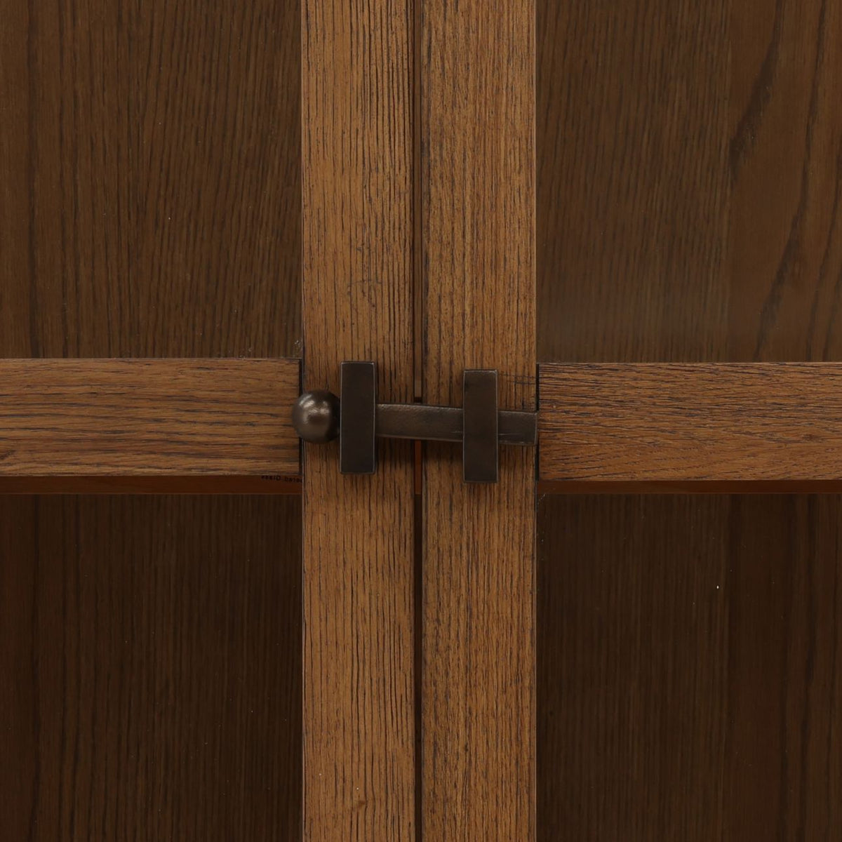 Hawthorne tall oak display cabinet in dark brown with glass-paneled doors and sides and a bronze-finished iron base.