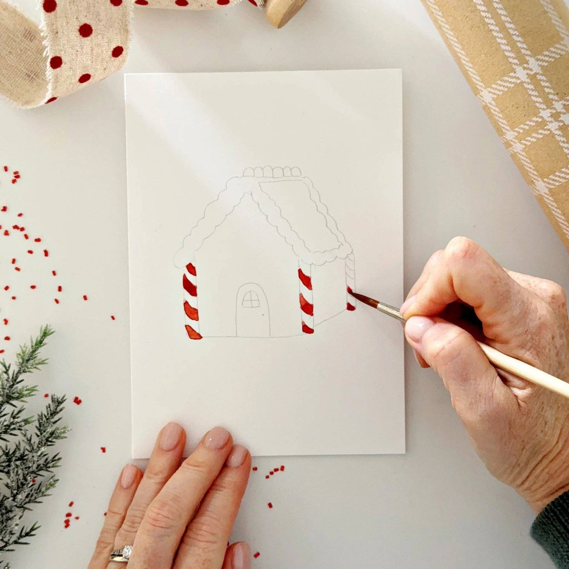 Close-up of watercolor-ready Christmas notecards featuring festive gingerbread and holiday illustrations printed on premium watercolor paper.