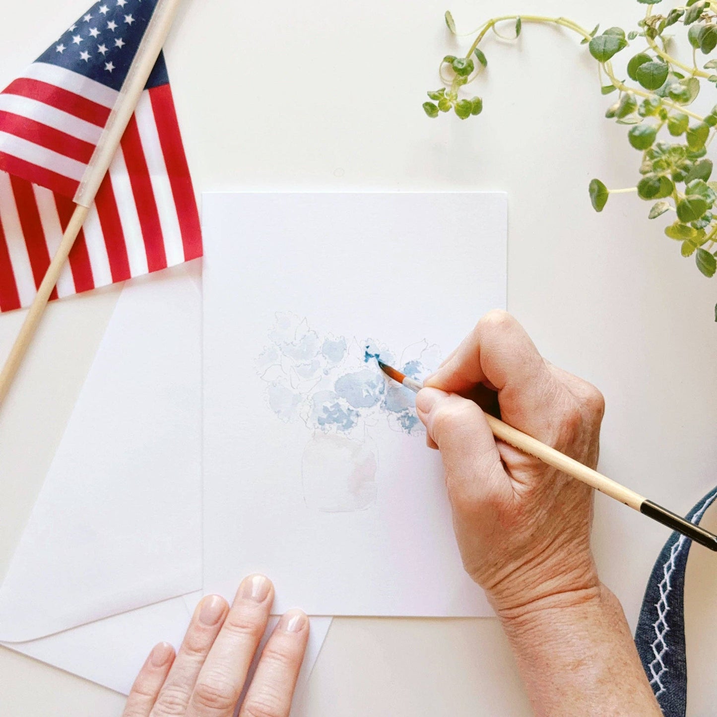 Watercolor notecard set being painted with included Americana-inspired designs.
