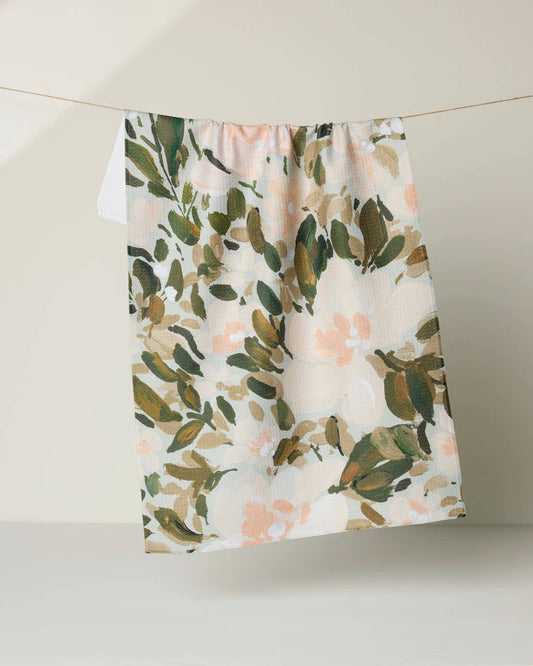 Floral patterned fabric hanging on a line against a neutral background