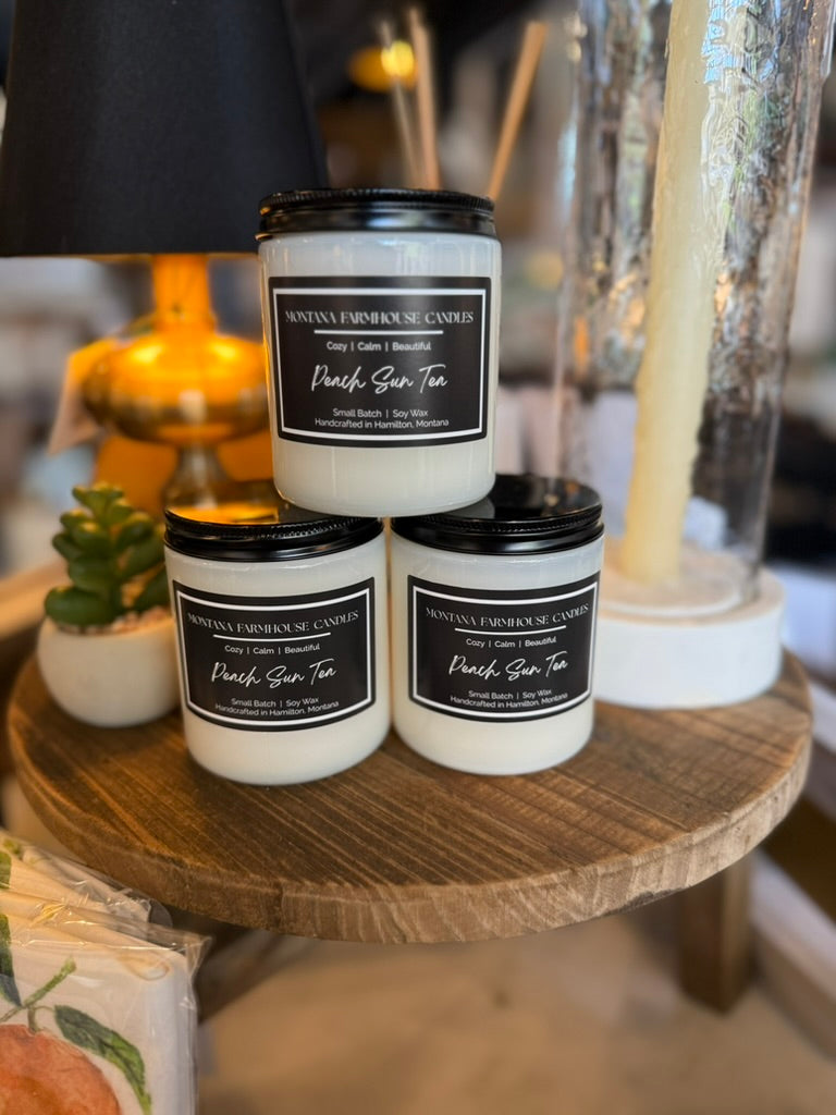 Peach Sun Tea soy candle in a transparent opaline white tumbler, hand-poured in Montana.