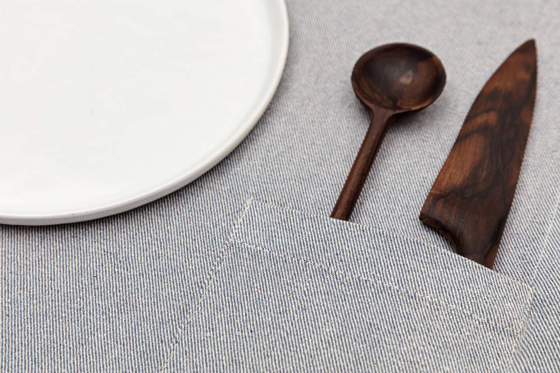 Denim placemat with functional storage pocket and durable cotton construction.