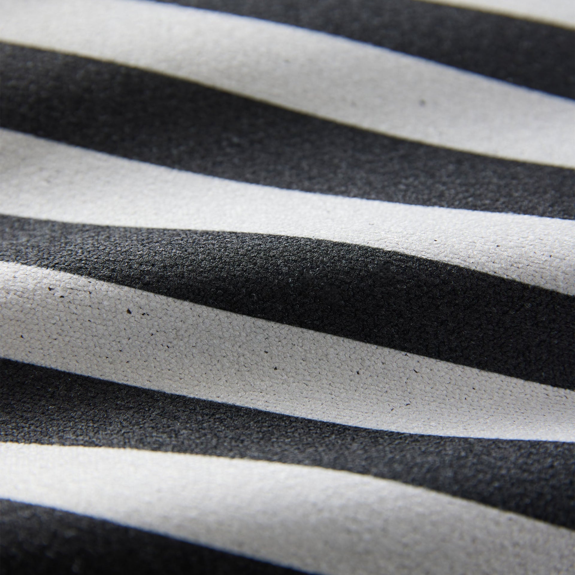 Close-up of the Poolside Black Nomadix towel highlighting the textured performance fabric, striped pattern, and built-in hanging loop.