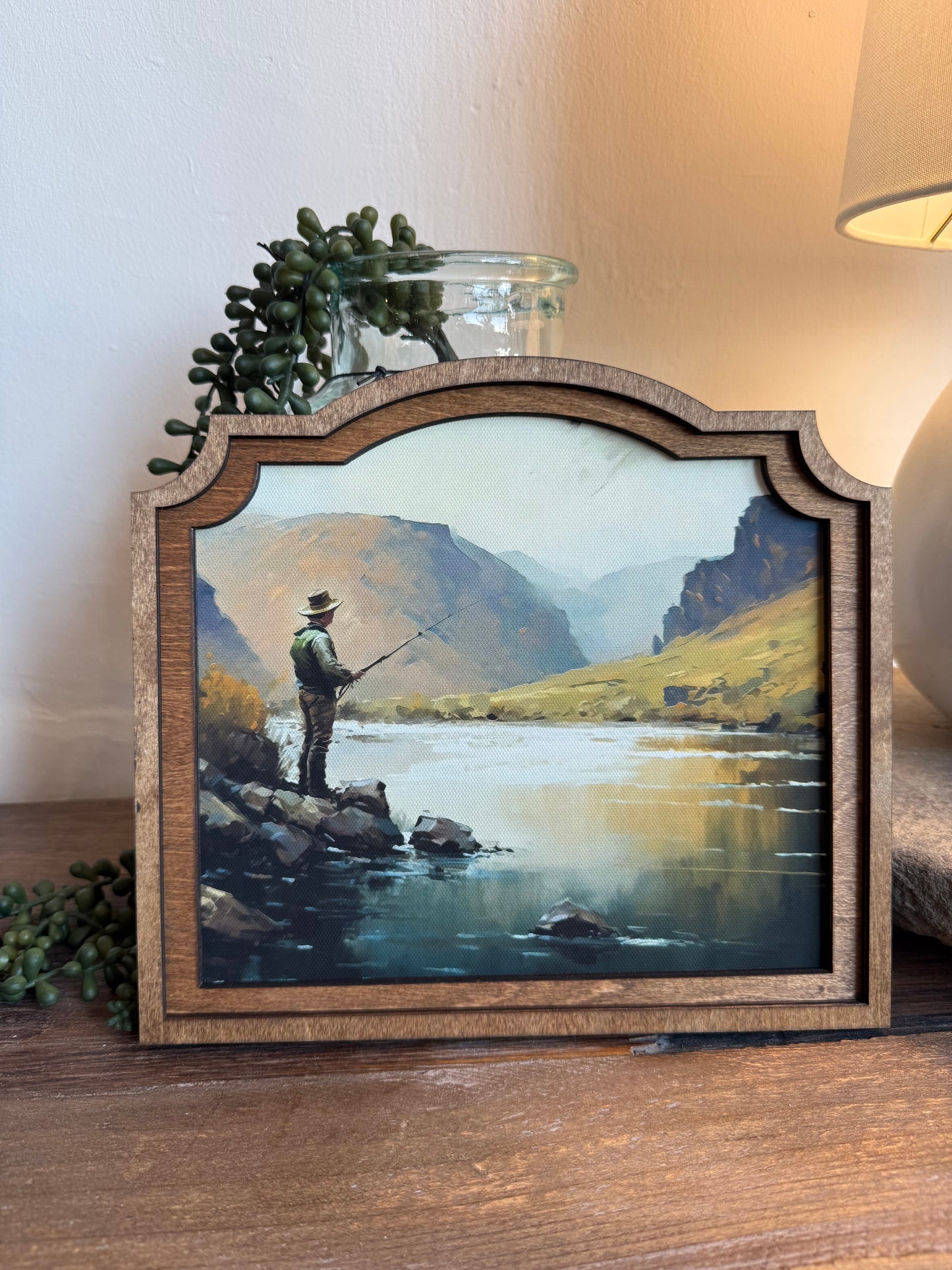 Provincial Fisherman Framed Canvas Art featuring a timeless fishing scene in a handcrafted custom-shaped birch wood frame with an Early American finish.