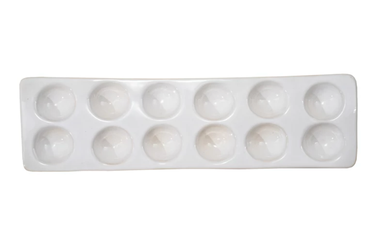White stoneware egg holder with a reactive glaze finish designed to hold 12 eggs.