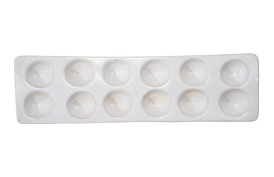 White stoneware egg holder with a reactive glaze finish designed to hold 12 eggs.