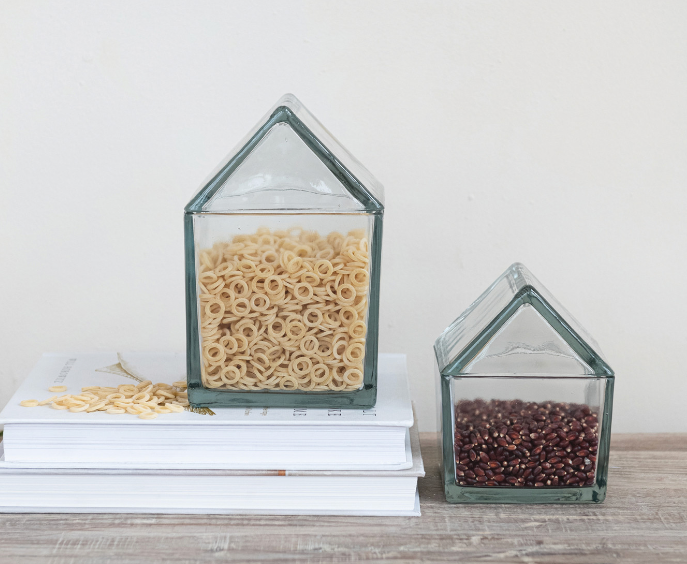 Recycled glass house-shaped jars with lids for decorative storage and display.