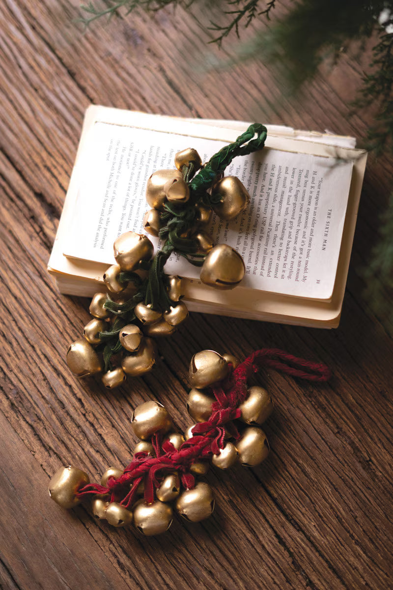 Cluster of metallic jingle bells tied with a rich red velvet ribbon for classic Christmas decorating.