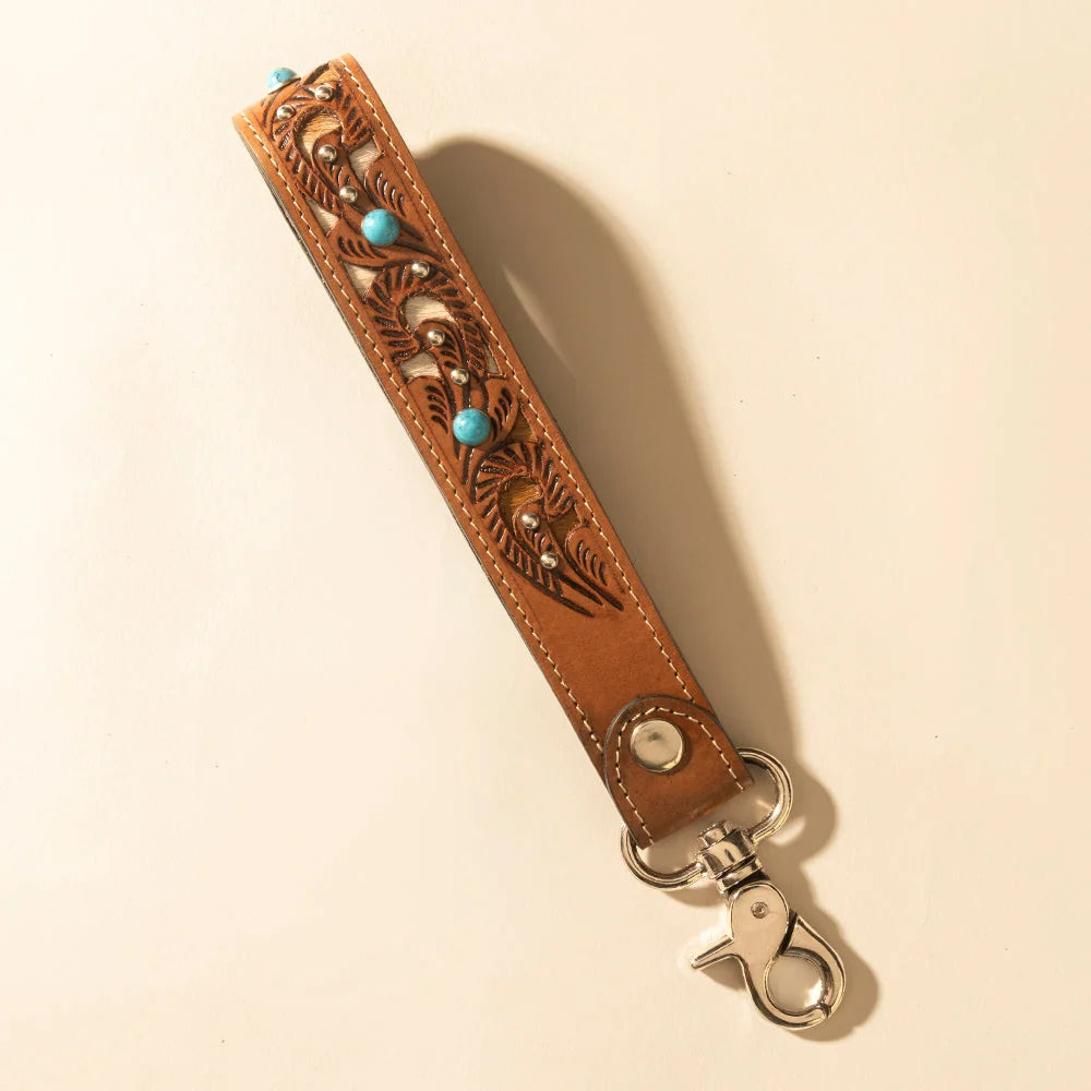 River Glen hand-tooled leather and hair-on hide key fob in honey tan with turquoise accents and metal clasp.
