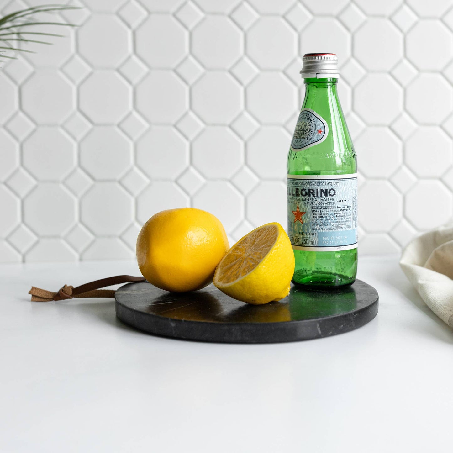 Black marble serving board arranged with lemons and sparkling water for entertaining.