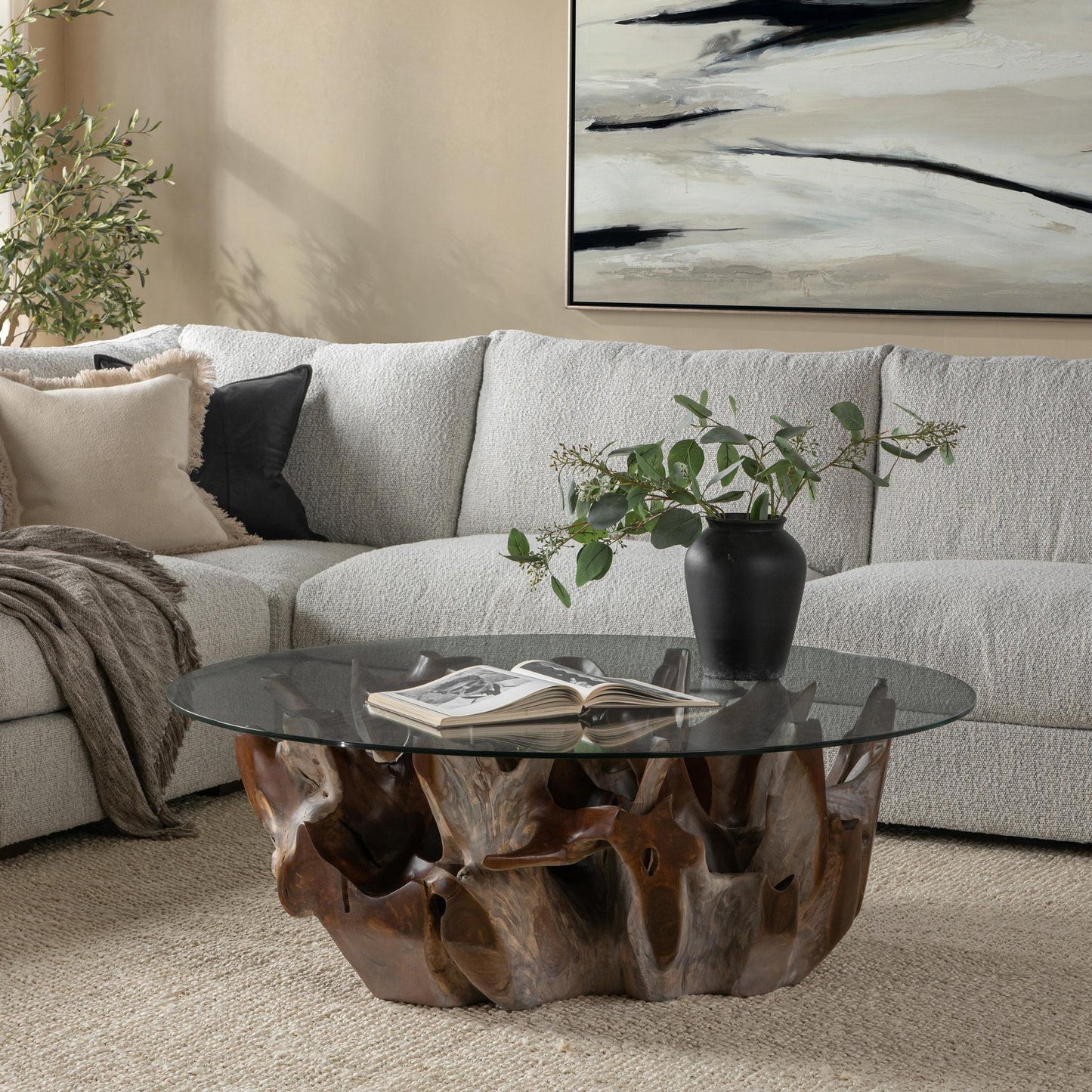 Hailey teak root and glass coffee table styled in an organic modern living room with linen seating, leather accents, and warm wood furnishings.