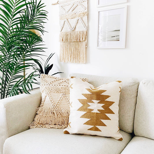 Neutral handwoven kilim pillow layered on a linen sofa in an organic modern living room.
