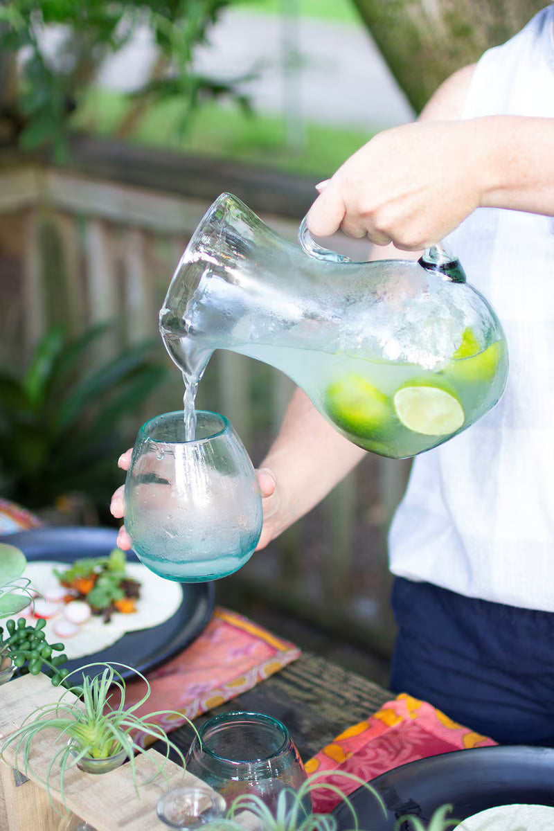 Small glass pitcher styled as a vase with fresh lime.