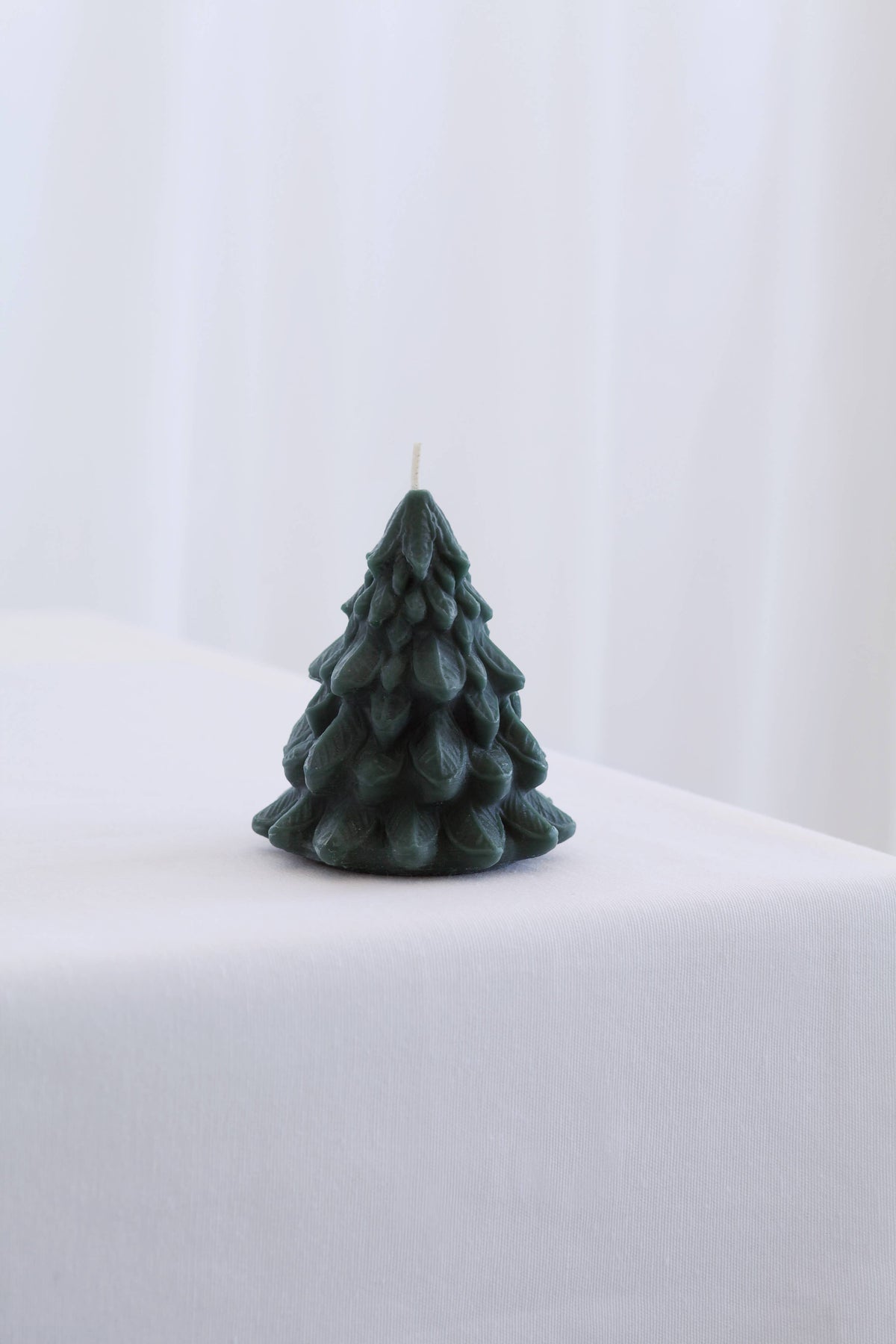 Large sculpted beeswax Christmas tree candle by Mo&Co Home, measuring 3 7/8 inches tall.