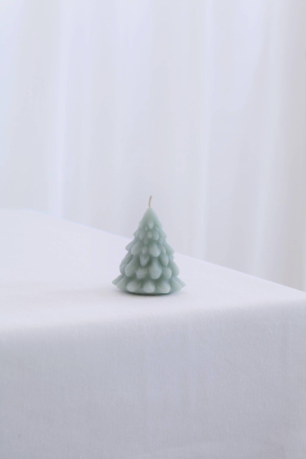 Small hand-poured beeswax Christmas tree candle by Mo&Co Home, measuring 2 5/8 inches tall.