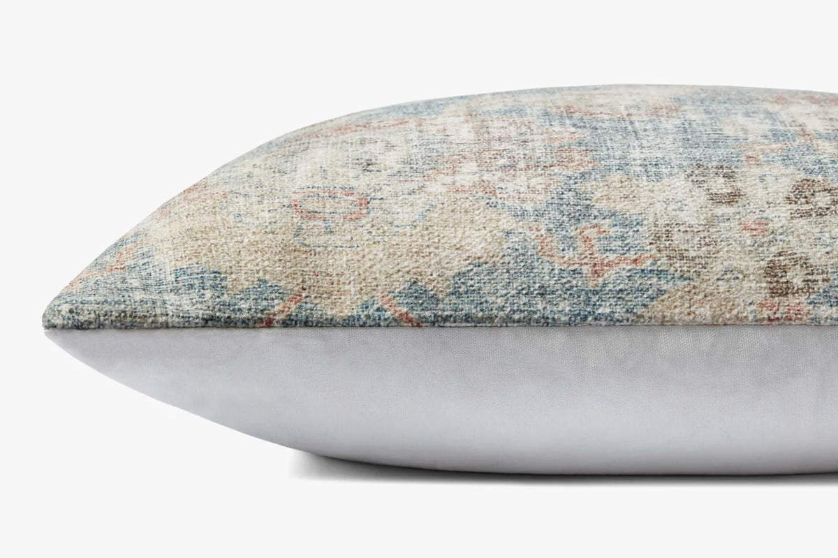Close-up of the Pacifica pillow highlighting the woven texture, soft sky blue tones, knife-edge finish, and hidden zipper with antique bronze Loloi logo pull.
