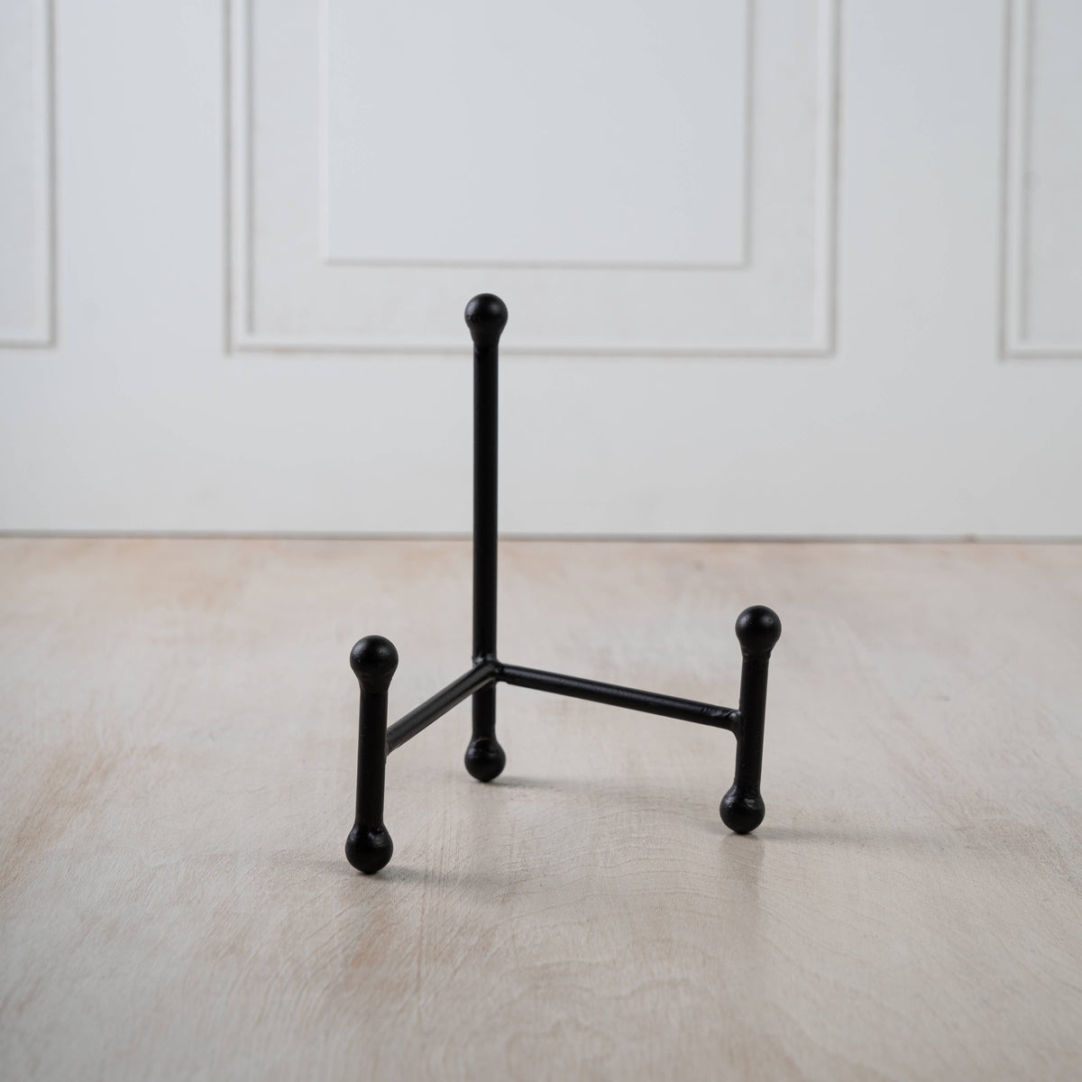 Compact iron easel designed for displaying small artwork, photographs, plates, and decorative objects.