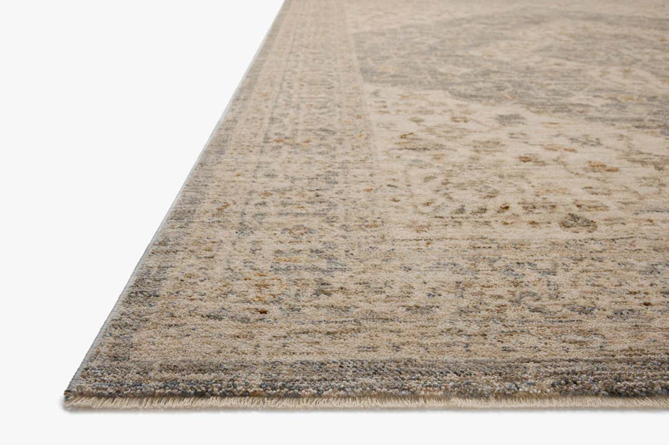 Vintage-inspired area rug with muted denim blue accents and soft neutral tones.