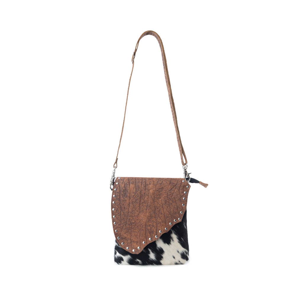 Stonebrook Canvas & Hairon Crossbody Bag in Spotted Ivory featuring genuine hair-on cowhide, textured leather, decorative silver studs, and an adjustable crossbody strap.